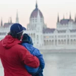 egy apuka és a fia budapesten a parlamenttel szemben a duna budai oldalán népességcsökkenés statisztika