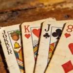 Magyar és francia játékkártyák egymás mellett egy asztalon, römihez használt lapok közelről